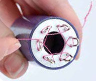 Wire being wrapped around the spokes of the knitter